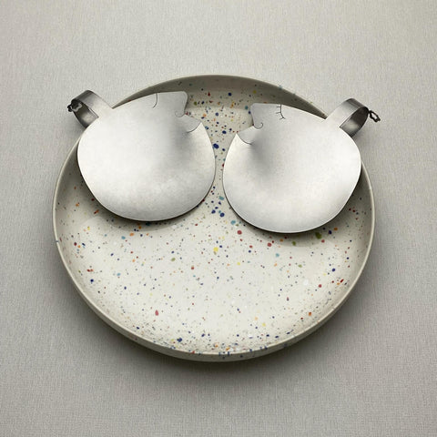 Two stainless steel Those Two face salad servers in a speckled bowl