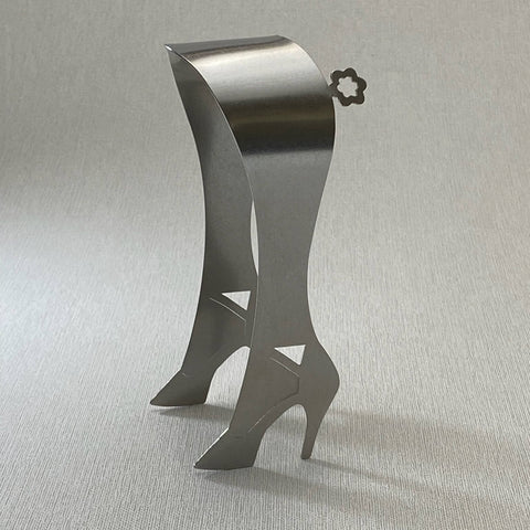 Stainless steel serving tongs in high heel design standing up facing left on grey background