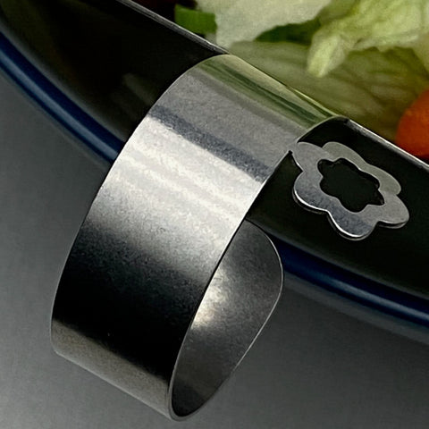 Close up of flower detail on ring handle of Those Two stainless steel salad servers