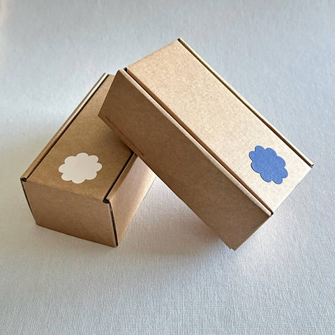 Two brown gift boxes for serving tongs on grey background