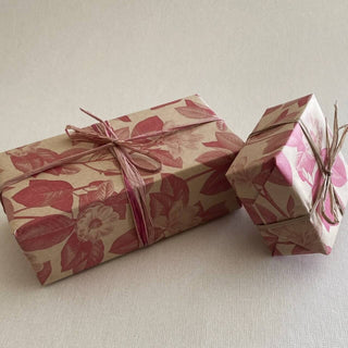 Complimentary between you and me gift wrapping in pink botanical paper tied with natural raffia