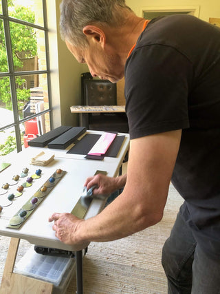 Studio maker polishing a handcrafted stainless steel serving piece