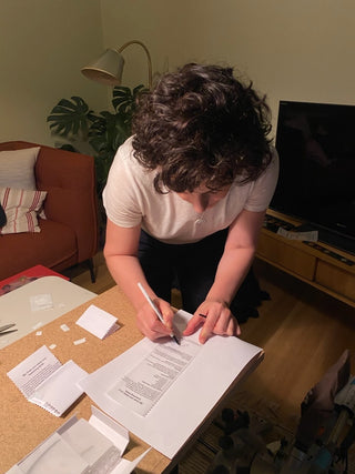 Between You and Me maker signing studio care cards for handcrafted serving pieces