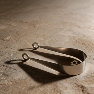 Circles stainless steel server resting on textured stone surface with dramatic shadows