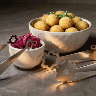 Stainless steel Kaleidoscope and Flowers serving pieces beside arancini balls and pickled cabbage in ceramic bowls