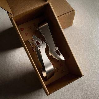 Pair of handcrafted stainless steel Off to See the Wizard serving pieces presented in patterned kraft gift box