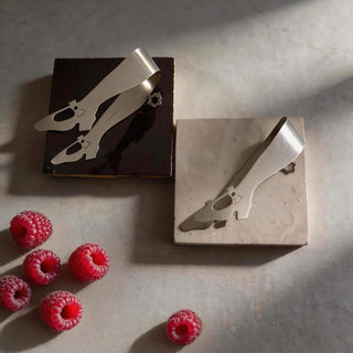 Handcrafted stainless steel Off to See the Wizard serving pieces resting on handcrafted brown and cream table tiles beside fresh raspberries