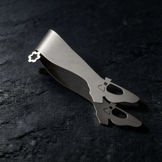 Handcrafted stainless steel Off to See the Wizard shoe-shaped serving piece resting on dark textured surface