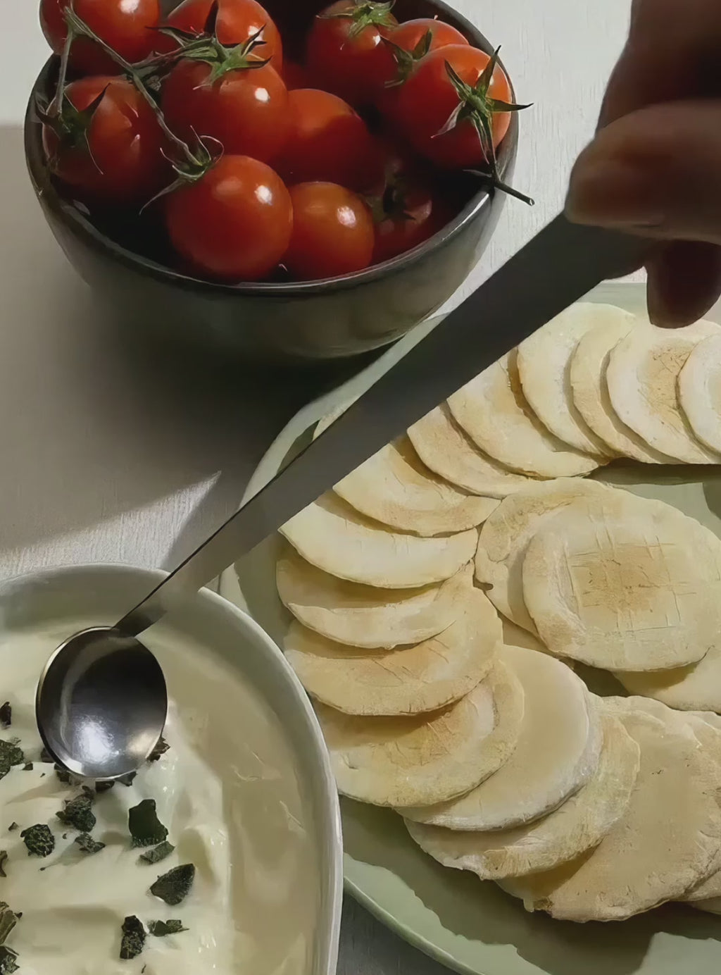 Video of the Best Seat in the House handcrafted stainless steel tiny serving ladle scooping creamy dip beside crispbread and cherry tomatoes.