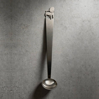 Single Cabriole stainless steel tiny serving ladle on a textured grey surface