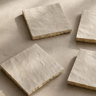 Set of four Soft Cream handcrafted ceramic table tiles with softly uneven surfaces and natural clay edges