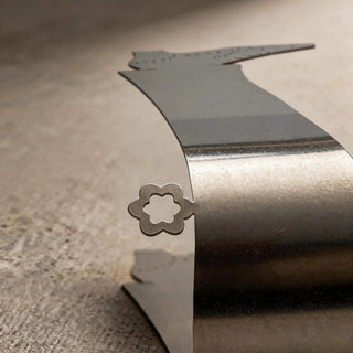 Close-up detail of stainless steel Tap Shoe server with flower-shaped accent