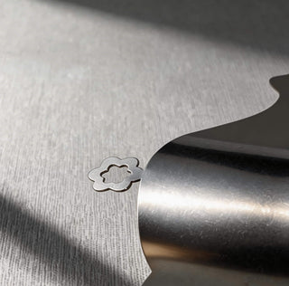 Close-up of flower detail on handcrafted stainless steel high heel serving piece from the Stepping Out collection