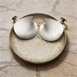 Pair of Those Two handcrafted stainless steel salad servers with gently smiling faces resting on speckled ceramic bowl