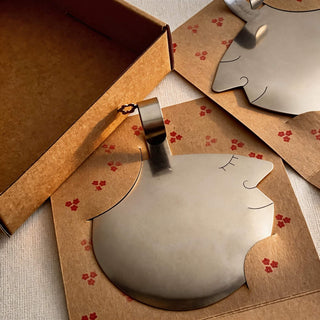 Those Two stainless steel salad servers with softly sculptural face profiles presented in patterned kraft packaging
