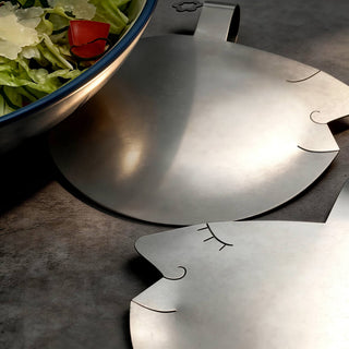 Close-up of softly sculptural face detail on Those Two stainless steel salad servers, beside bowl of green salad with parmesan 