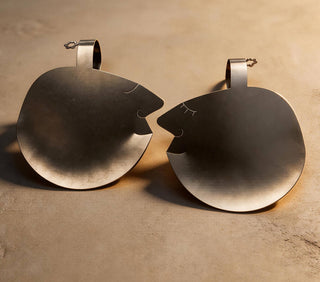 Pair of Those Two handcrafted stainless steel salad servers facing one another on stone surface